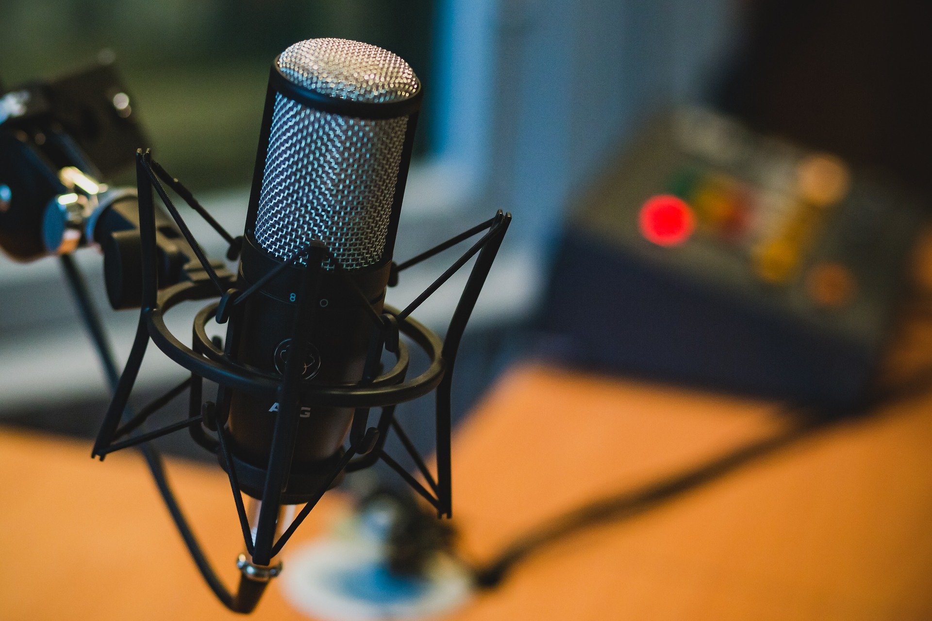 A detailed shot of a professional microphone with the studio gently blurred in the background.